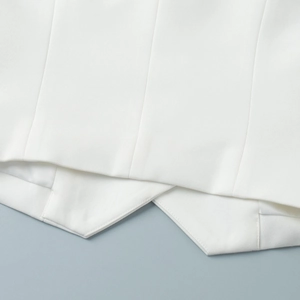 Macro detail of white vest with V-shaped hem and premium twill fabric texture