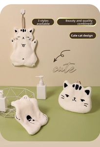 Detailed view of soft coral fleece cat towels in three styles hanging in a cozy bathroom