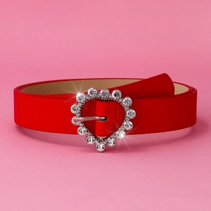 Close-up of red leather belt featuring a sparkling heart-shaped rhinestone buckle detail