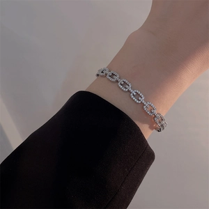 Close-up of a shimmering silver bracelet with dense pavé stones worn on a model's wrist