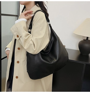 Nahaufnahme einer schwarzen Hobo-Tasche aus Leder mit Lychee-Maserung und Silberringen