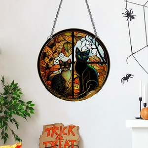 Detail of round Halloween suncatcher with black cats, autumn leaves and hanging metal chain