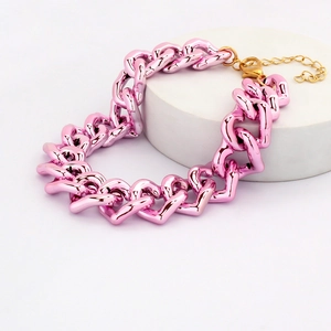 Detail of pink heart-shaped link pet collar with golden metal clasp on stone stand