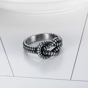 Bague en acier inoxydable argenté avec motif de nœud tressé vue sous un angle latéral