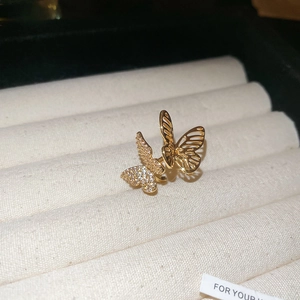 Detailed macro view of gold butterfly ring featuring zircon pavé and hollow metal design