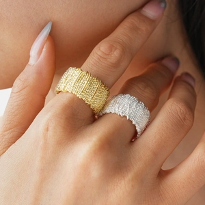 Macro detail of gold and silver metallic textured wide rings with woven pattern detail