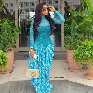 Close-up of tropical leaf print and mesh fabric detail on blue long-sleeve dress