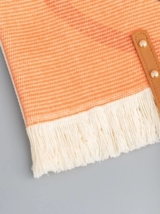 Canvas tassel tote bag in orange and white stripes with brown leather and rivet details