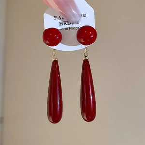 Detail of red water drop earrings on a 925 silver stud shown on a jewelry display card
