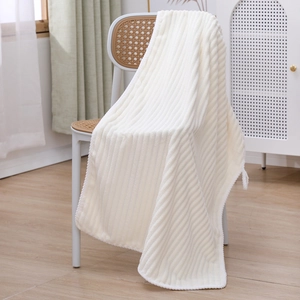 Detailed close-up of a white coral fleece towel with a vertical textured stripe design