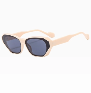 Close-up of beige cat-eye sunglasses with dark grey lenses in a stylish profile view