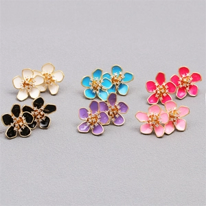 Macro view of flower stud earrings featuring colorful enamel petals and sparkly crystal centers