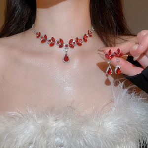 Close-up of elegant red gemstone flower necklace and earrings jewelry set on a model