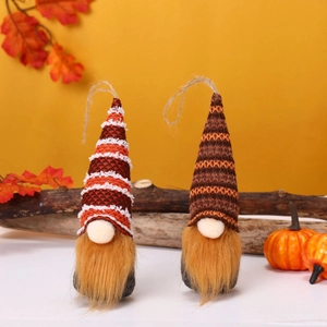 Detail of two handmade autumn gnomes with maple leaves and hanging ropes for Thanksgiving decor