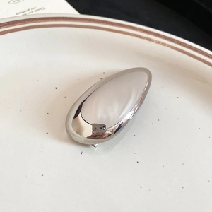 Macro view of water drop hair clip in silver finish on a vintage ceramic plate