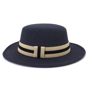 Detailed texture of dark grey wool felt flat top hat with striped beige ribbon band