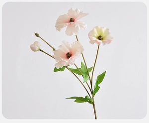 Detail of faux butterfly ranunculus with pink and yellow gradient petals on white background