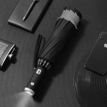 Detail of compact six-fold umbrella with integrated LED flashlight on the handle