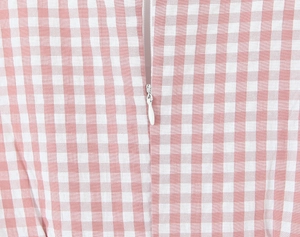 Detail of pink gingham fabric and white invisible zipper closure on the mini dress