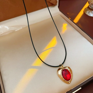 Detail of vintage gold heart necklace with red crystal pendant in jewelry gift box