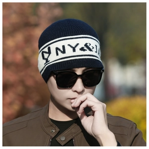 Détail du bonnet en tricot d'hiver avec rayures bleu marine et broderie NY&J élégante