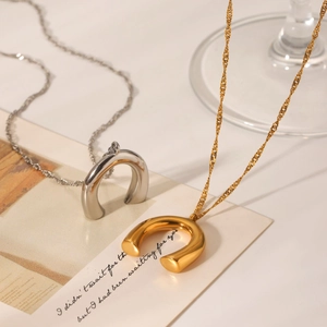 U-förmige Hufeisen-Halsketten in Gold und Silber auf einer stilvollen Karte präsentiert