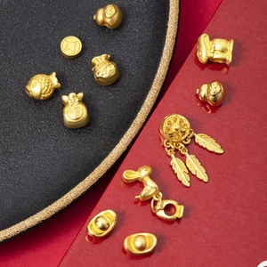 Detailed close-up of golden metal jewelry pendants with rabbit and money bag shapes