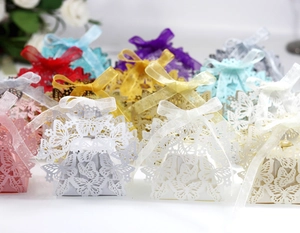 Macro view of laser-cut butterfly wedding favor boxes with elegant satin ribbon bows