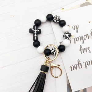Silicone beaded keychain bracelet with leopard print beads, black cross, and leather tassel