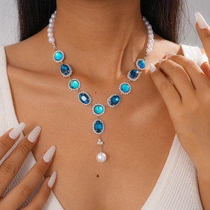Detail of vintage necklace with blue rhinestones and pearls on model neck