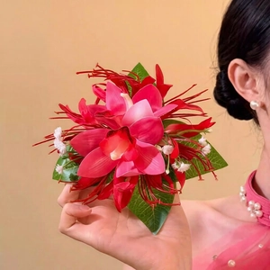 Detailed close-up of a vibrant pink fabric orchid hair clip with red stamens and green leaves
