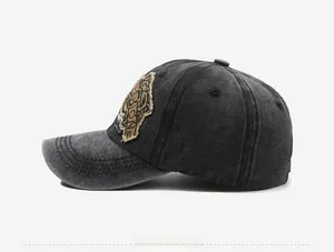 Dettaglio della toppa con tigre ricamata sul cappello da baseball in denim grigio scuro