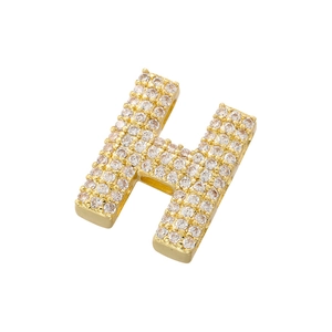 Macro shot of gold-plated letter H pendant with handset cubic zirconia crystals