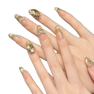Ongles à presser dégradé doré avec strass 3D et zircon sur un fond blanc pour manucure