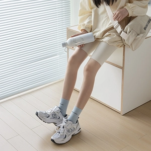 Women's cream-colored breathable crew socks with letters and white athletic sneakers