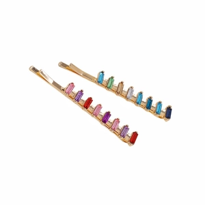 Golden hair clips with colorful rectangular crystals shown against a white background