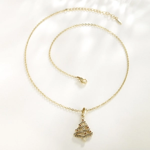 Golden Christmas tree necklace for women with colorful zircon stones on ivory background
