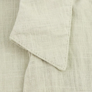 Detailed view of light beige linen blend fabric texture and stitching on the shirt collar