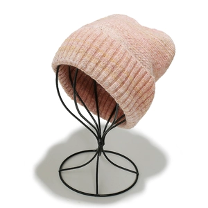 Detailed texture of pink knit beanie with fuzzy texture on a black wire hat stand