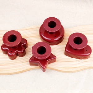 Red non-stick donut molds in flower, circle, star and heart shapes on wood board