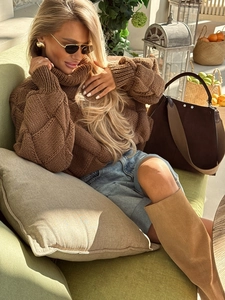 Detailed texture of brown chunky knit turtleneck sweater and suede high boots
