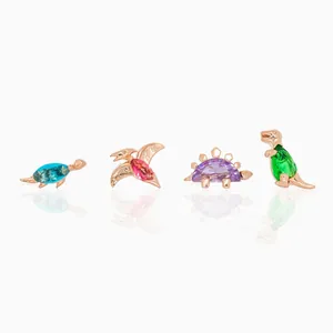 Macro view of dinosaur earrings with colored gemstones and rose gold finish detailing