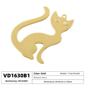 Detail view of cat charm with brass material, gold finish and spinel stone eyes