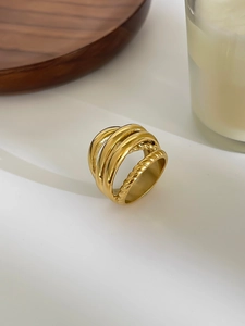 Detail shot of a wide gold-plated stainless steel ring with layered twist and smooth bands