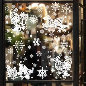 White Christmas window decals with gnomes, snowflakes and reindeer on a glass pane