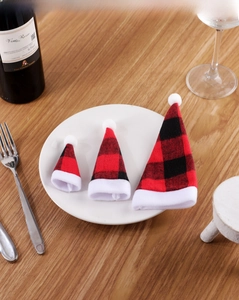 Three sizes of red and black checkered Christmas mini hats for cutlery and wine bottles
