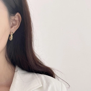 Golden minimalist twisted spiral earrings in 925 sterling silver worn by a model