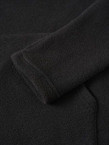 Close-up of the black fleece fabric texture and sleeve seam on the casual sweatshirt