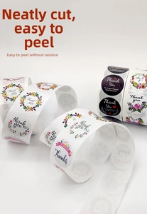 Close-up of floral Thank You stickers in white and black rolls for gift sealing