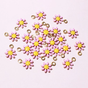 Close-up of pink daisy charms with gold edges for DIY jewelry making accessories